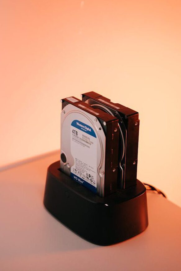 services-02 Dual external hard drives on a docking station with an orange backdrop.