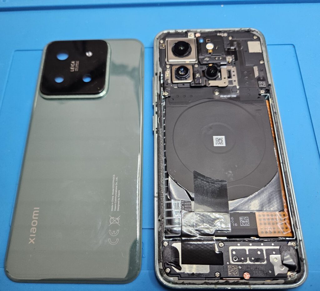 Geöffnetes Xiaomi-Smartphone bei der Reparatur mit sichtbaren Kameramodulen und Innenkomponenten im Raum Landshut